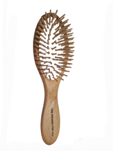 Load image into Gallery viewer,  Natural rubber reduces static hair. The use of a cushion in our uniquely designed brushes makes brushing your hair more comfortable, since it follows the curves of your hair, reducing unpleasant friction. However, it does provide for sufficient pressure to allow the bristles to gently massage and stimulate your scalp. Natural rubber also is anti-static. If you notice a small hole in the cushion, this is not a manufacturing mistake, but a way to prevent moisture getting trapped underneath the cushion.
